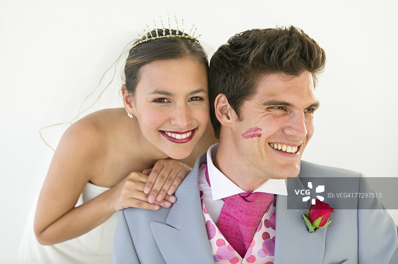 脸颊带着口红印记的新郎和微笑的新娘图片素材