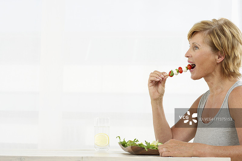 年长的女人吃蔬菜烤肉串图片素材