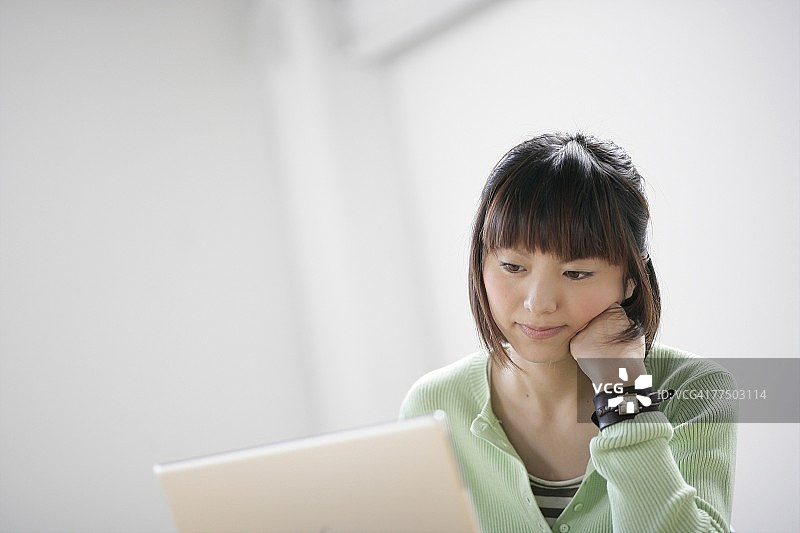 年轻女子在用笔记本电脑图片素材