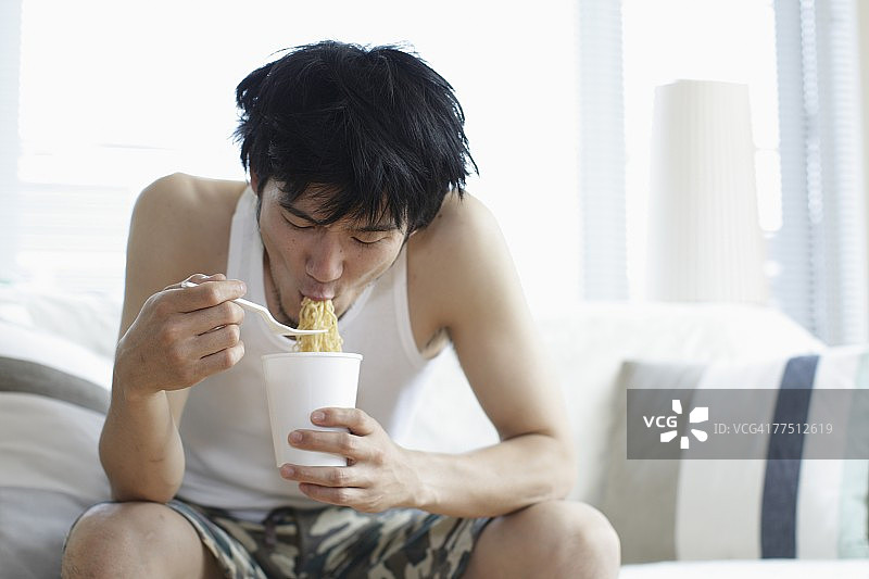 男人吃中国方便面图片素材