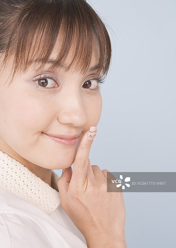 手指放在脸上休息的女人图片素材