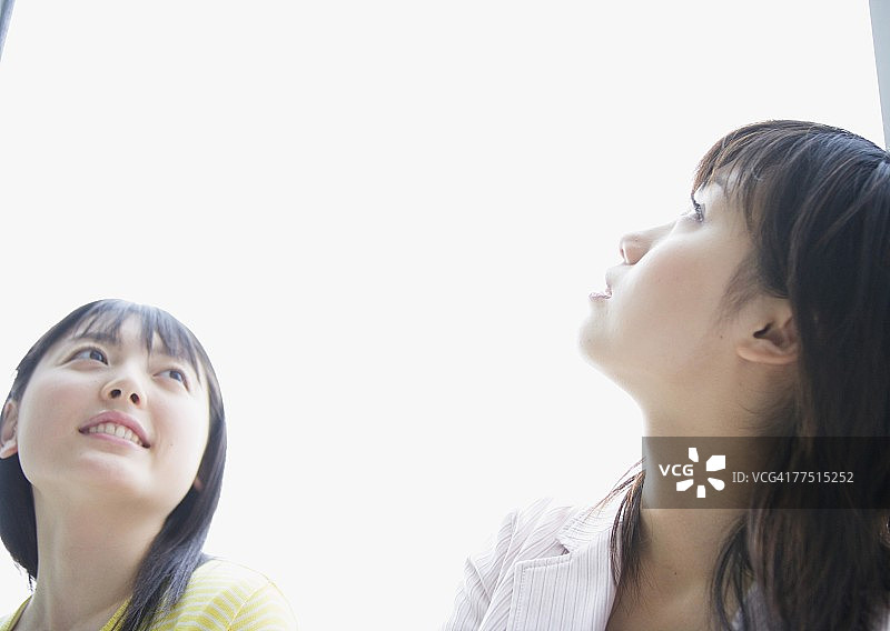 笑容满面的年轻女性抬头向上看图片素材