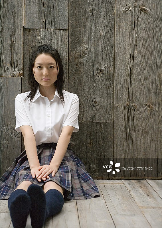 女孩穿着校服坐在地板上图片素材