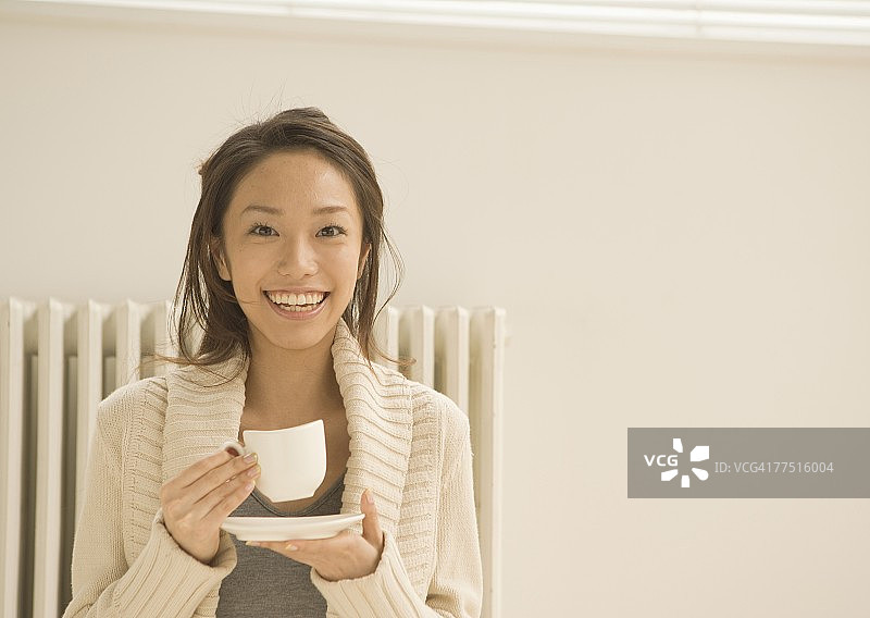 微笑的年轻女人喝着咖啡图片素材