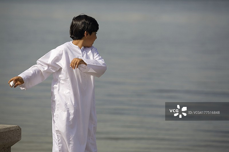 在海边玩耍的年轻阿拉伯男孩，阿拉伯联合酋长国迪拜图片素材