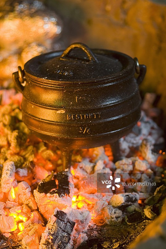 站在火堆余烬中的南非传统烹饪罐（Potjie Pot），福特代斯堡，南非东开普省图片素材