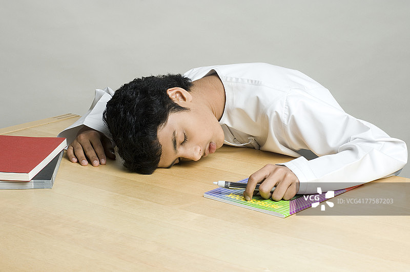 青少年男孩在桌子上睡觉图片素材