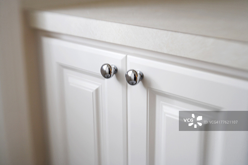 带银色旋钮的白色橱柜门细节图片素材
