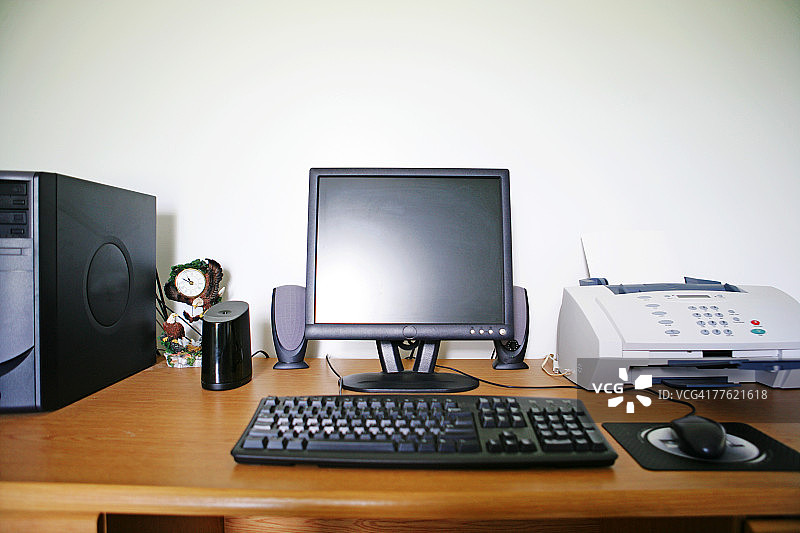 带有白色传真机和黑色家用电脑的木质桌子图片素材