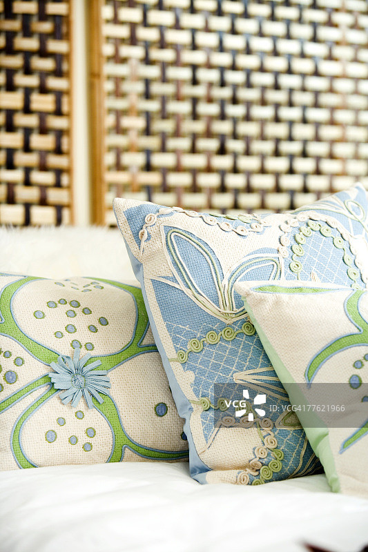 床上带有编织床头的热带印花枕头图片素材