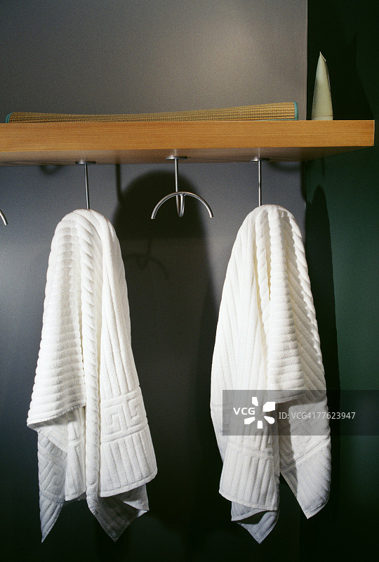 挂在衣架上的两条白色毛巾的正面照图片素材
