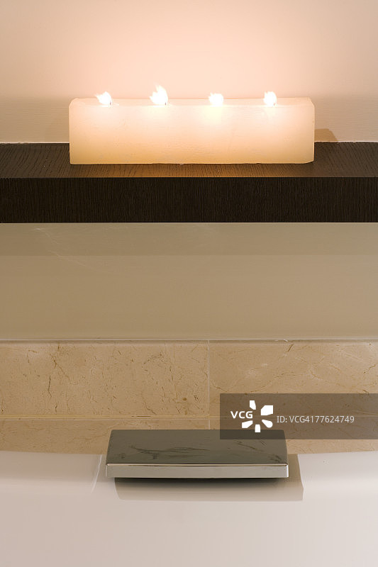 浴缸上方架子上的蜡烛和现代塞子图片素材
