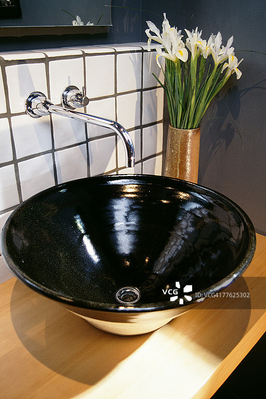经典黑色水槽，旁边放着鲜花图片素材