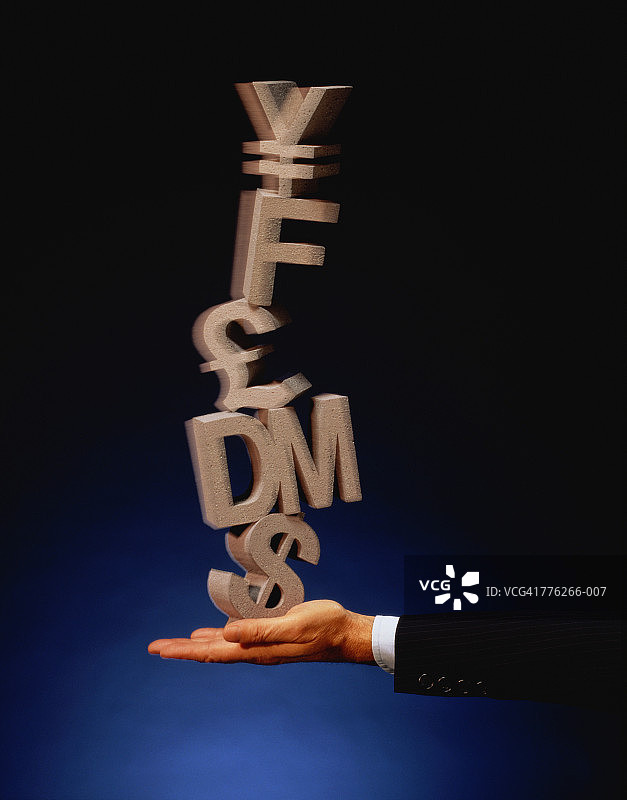 男人手上平衡的外币符号图片素材