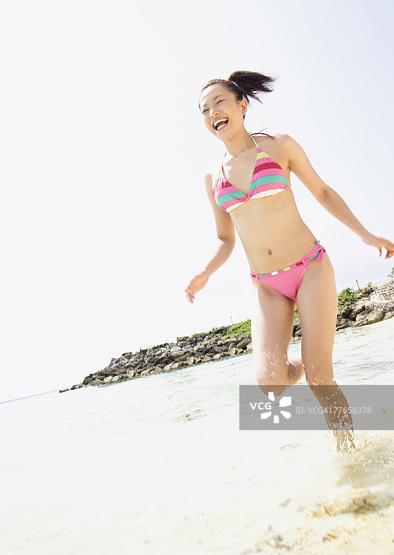在海滩上跑步的女人图片素材