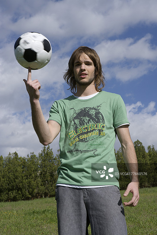 年轻男子用手指平衡足球图片素材