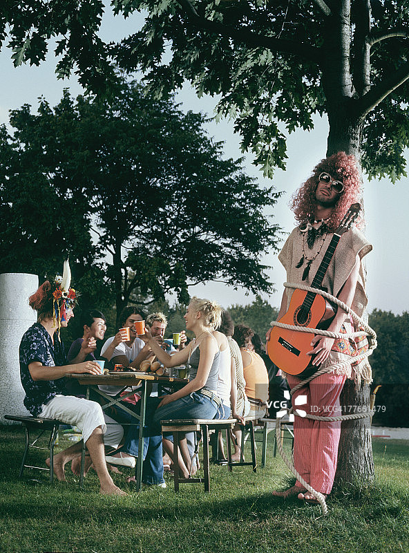 男人在野餐时把吉他绑在树上图片素材