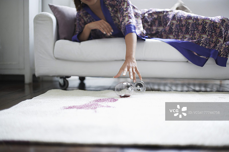 女子伸手去扶掉落的酒杯图片素材