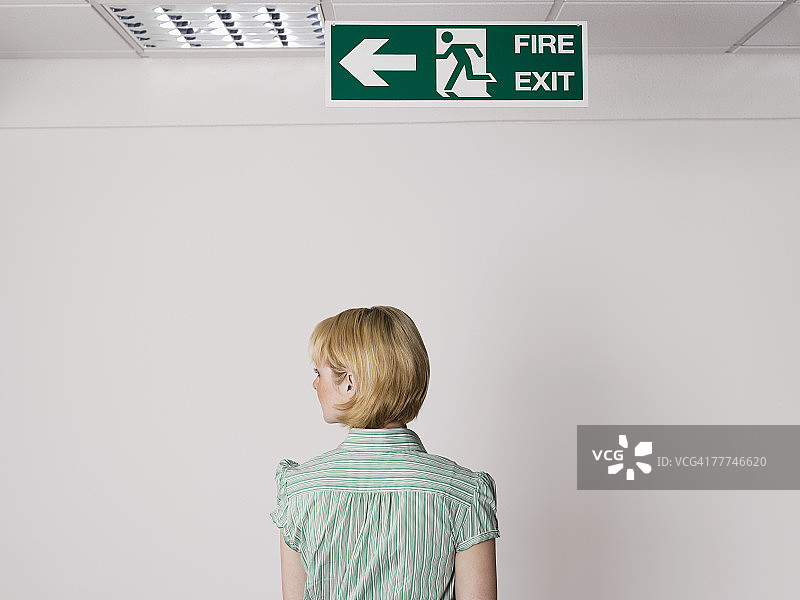 站在出口标志下的女商人图片素材