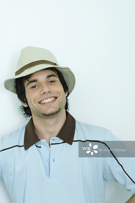 戴帽子的年轻男人对着镜头微笑肖像图片素材