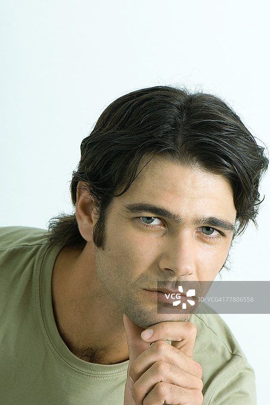 男人手托下巴看着镜头的肖像图片素材