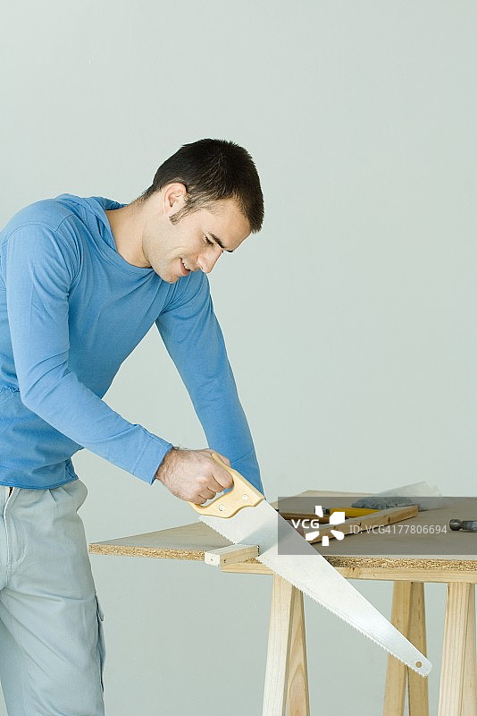 男人锯木板图片素材