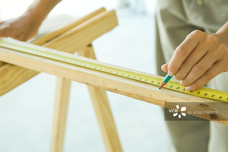 用卷尺测量木材的匿名人士图片素材