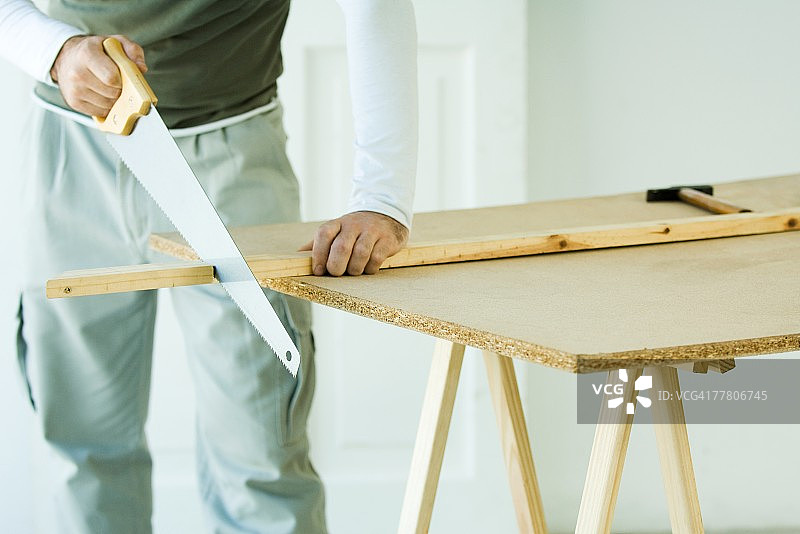 男人用锯子锯木头，局部视图图片素材