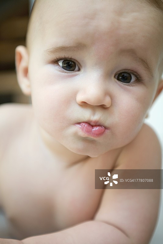 对着镜头皱眉的婴儿肖像图片素材