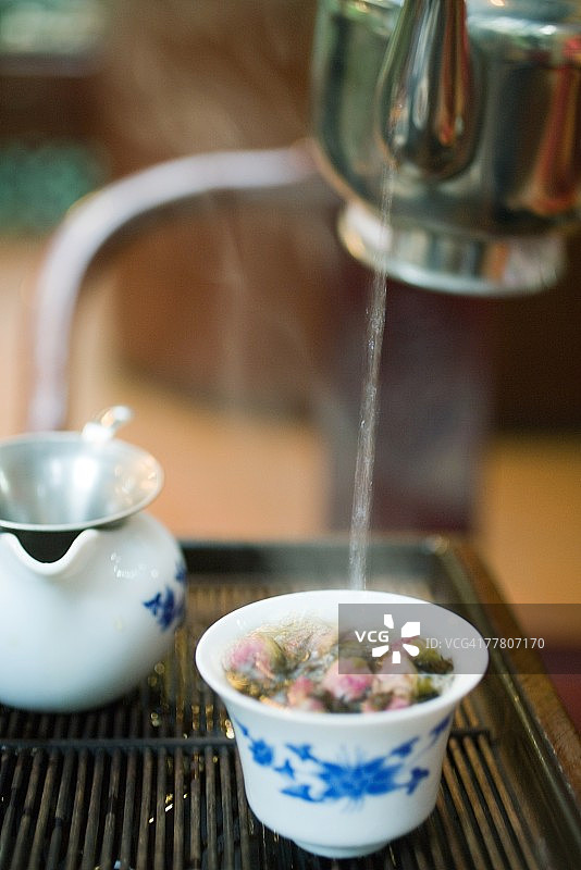 将热水倒入花茶混合物中图片素材