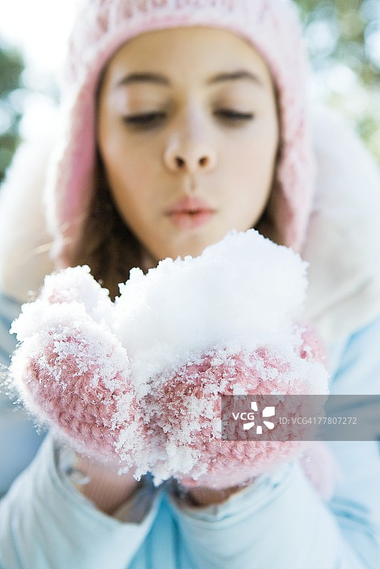 戴着手套的少女在吹雪图片素材
