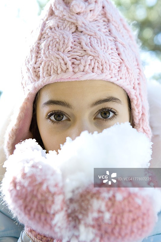 戴着手套吃雪的少女图片素材