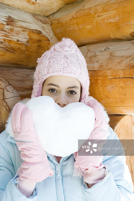 少女举着用雪做的心，肖像图片素材