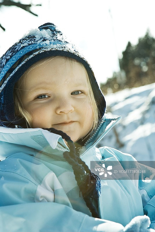 雪景中身穿冬装的幼儿女孩肖像图片素材