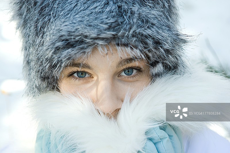 戴毛皮帽的少女，用毛皮领遮住嘴巴特写图片素材