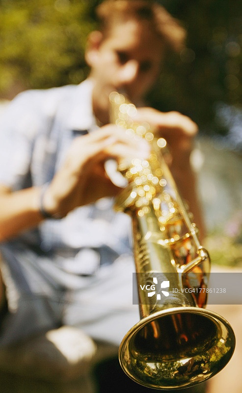 吹奏高音萨克斯的年轻男人图片素材