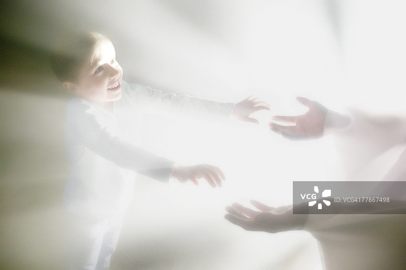 男孩伸手去触摸耶稣的手图片素材