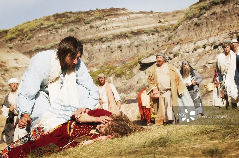 人群观看耶稣帮助躺在地上的人图片素材