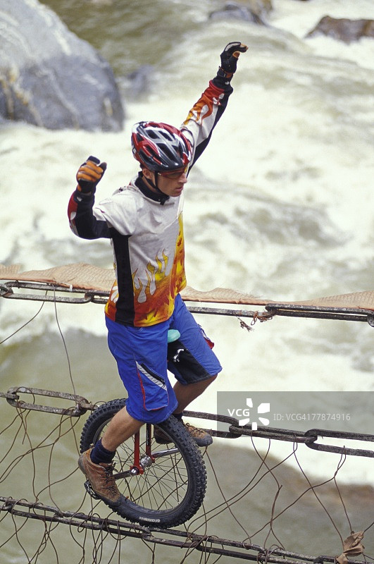 骑独轮车过河图片素材