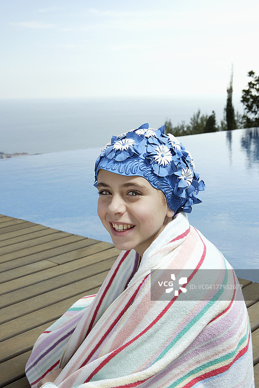 在无边泳池边的甲板上的女孩图片素材