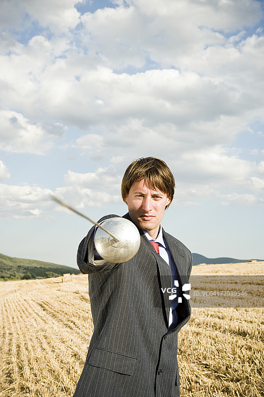 在麦田里击剑的商人图片素材