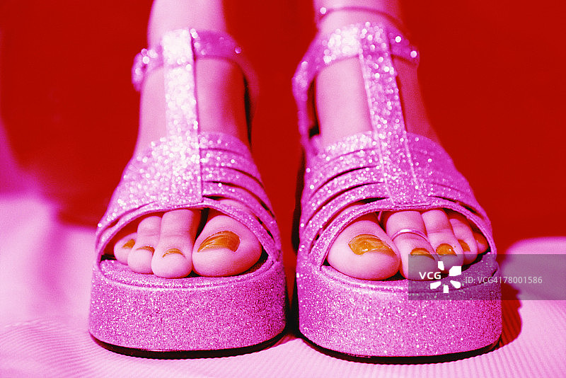 穿着闪光厚底凉鞋的女人的足部图片素材