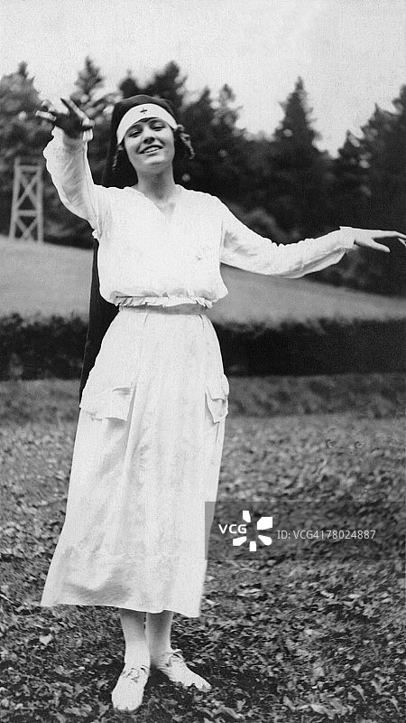 穿着护士服，张开双臂对着镜头微笑的女人图片素材