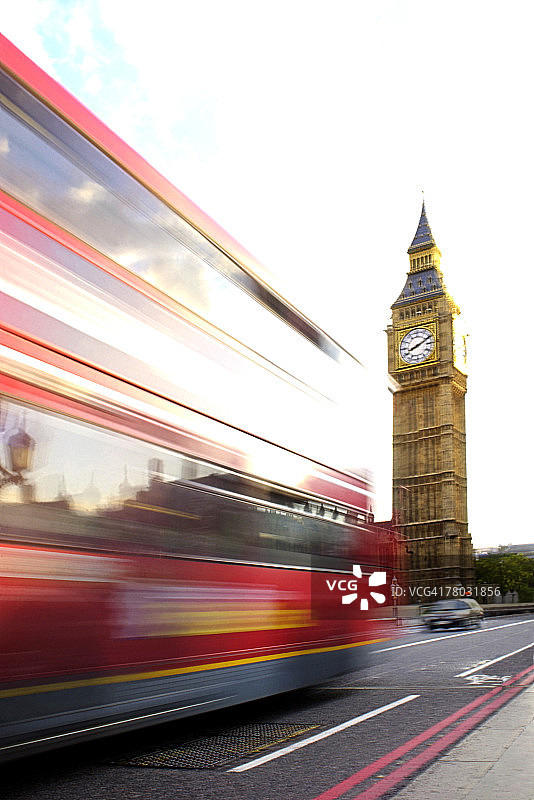 模糊的双层红色巴士沿着英国伦敦大本钟和议会大厦附近的一条道路行驶图片素材