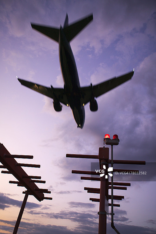 仰视视角下的飞机降落剪影图片素材