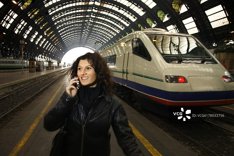 女子在米兰中央火车站打电话微笑图片素材