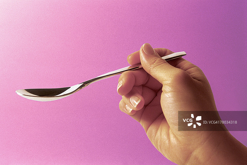 女人手拿茶匙图片素材