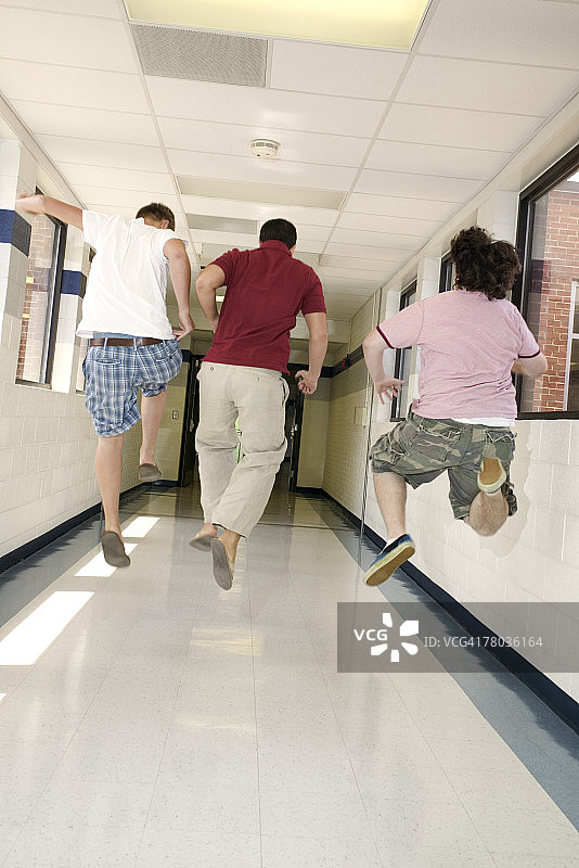 在走廊里跳跃的青少年男孩图片素材