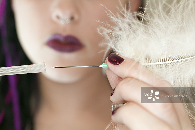 女人拔出羽毛针图片素材