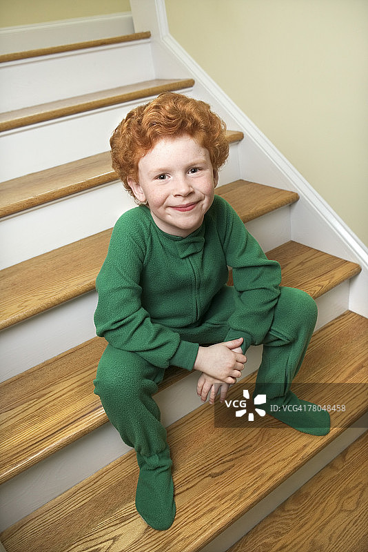 穿着睡衣坐在楼梯上的孩子图片素材